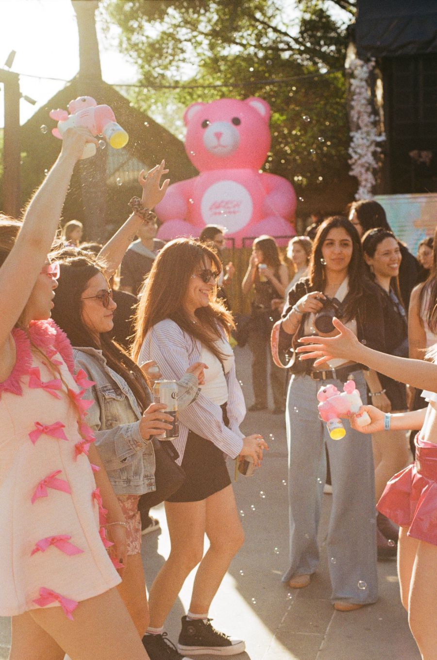 Grupo de chicas con pistolas de agua entre burbujas y un oso rosa gigante hinchable en Bresh.