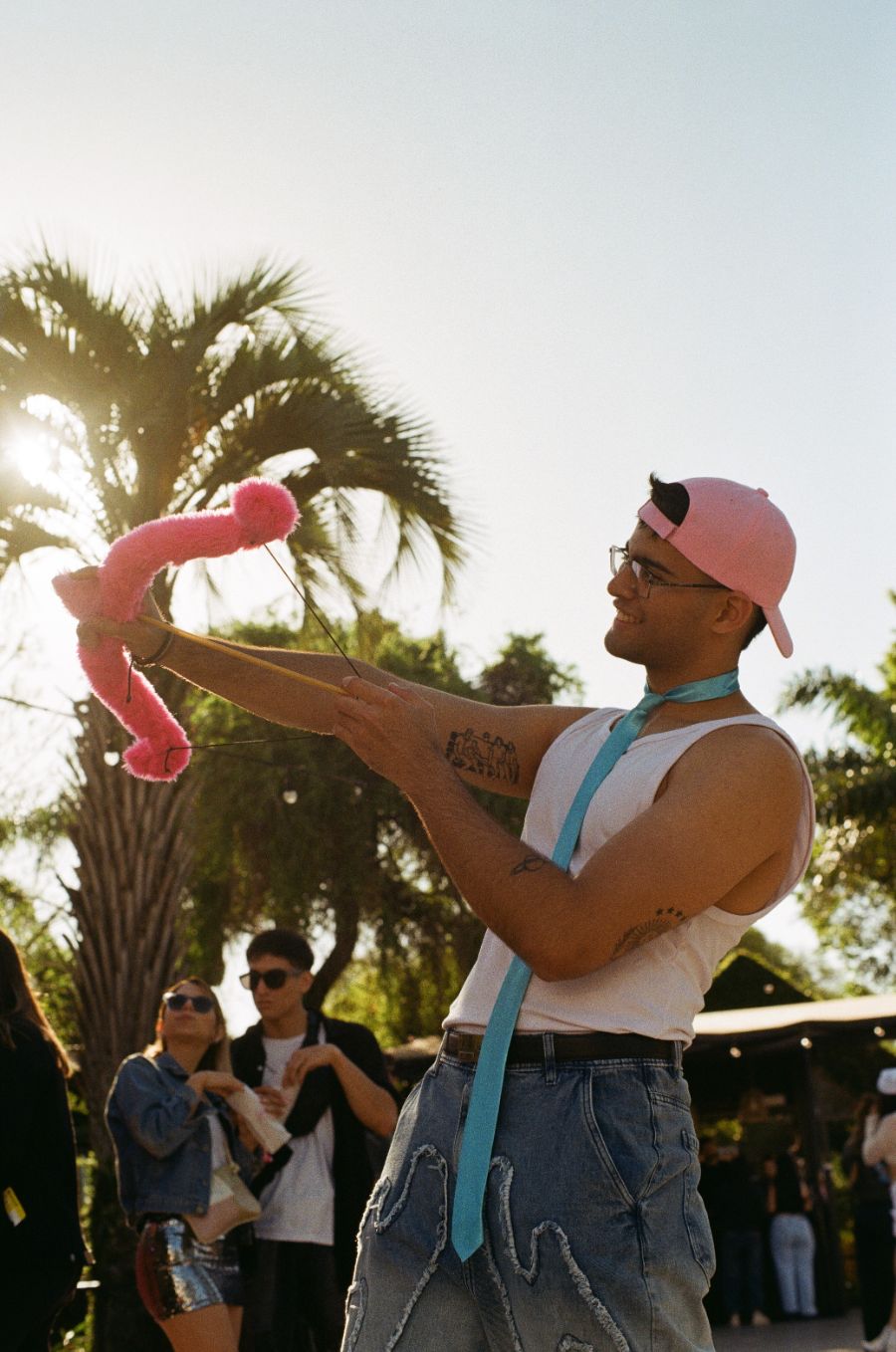 Chico disparando un tirachinas de flamenco de peluche rosa en Bresh.