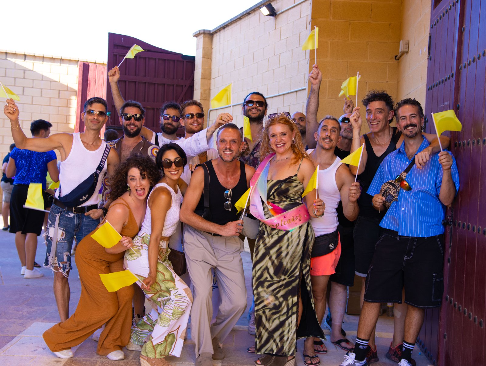 Grupo de asistentes con banderines amarillos del equipo amarillo posando en la entrada de la Plaza de Toros de Torremolinos antes de Furor The Show