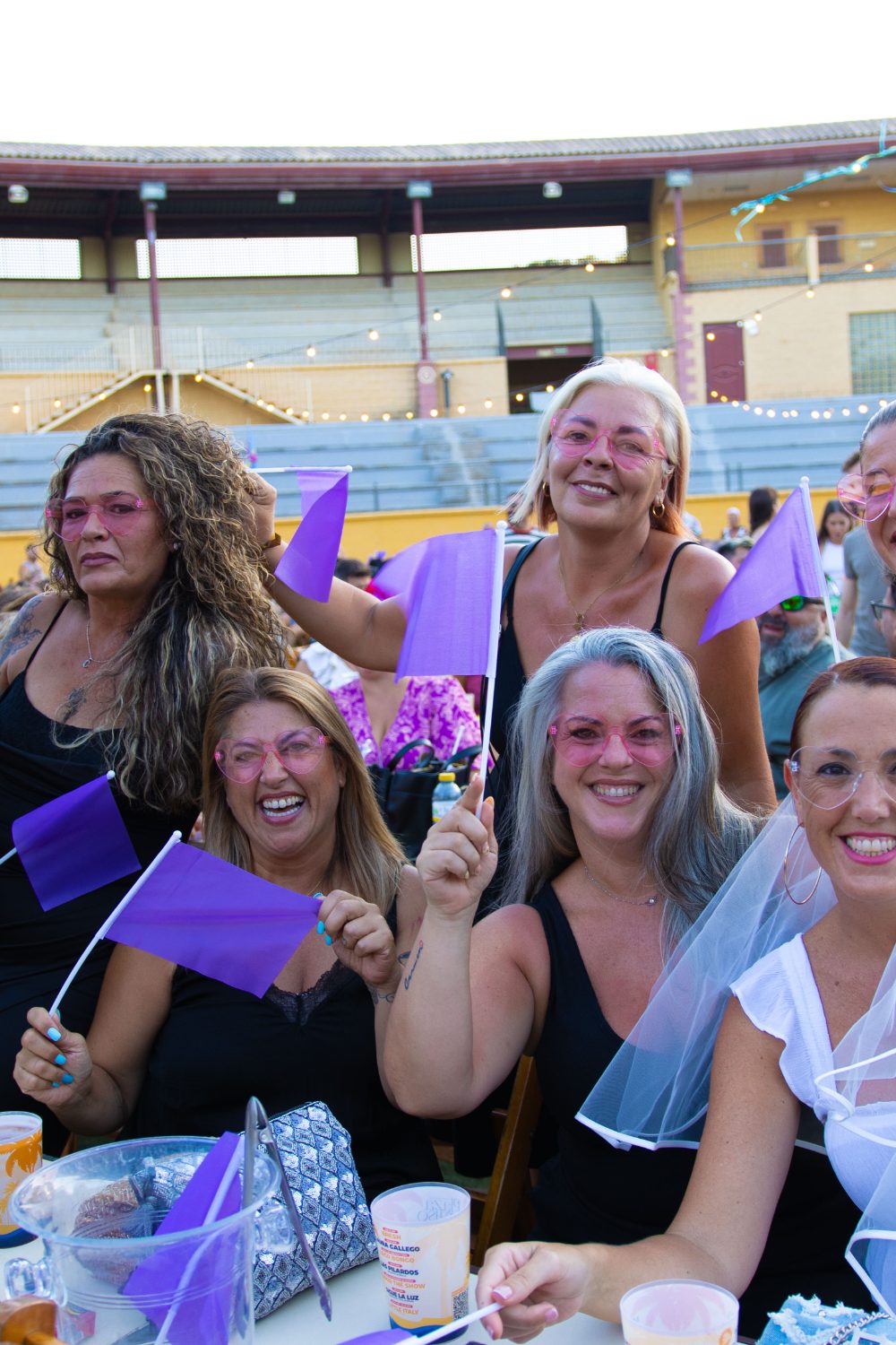 Grupo de mujeres con gafas de corazón rosas y banderines morados celebrando una despedida de soltera en Furor The Show, Torremolinos