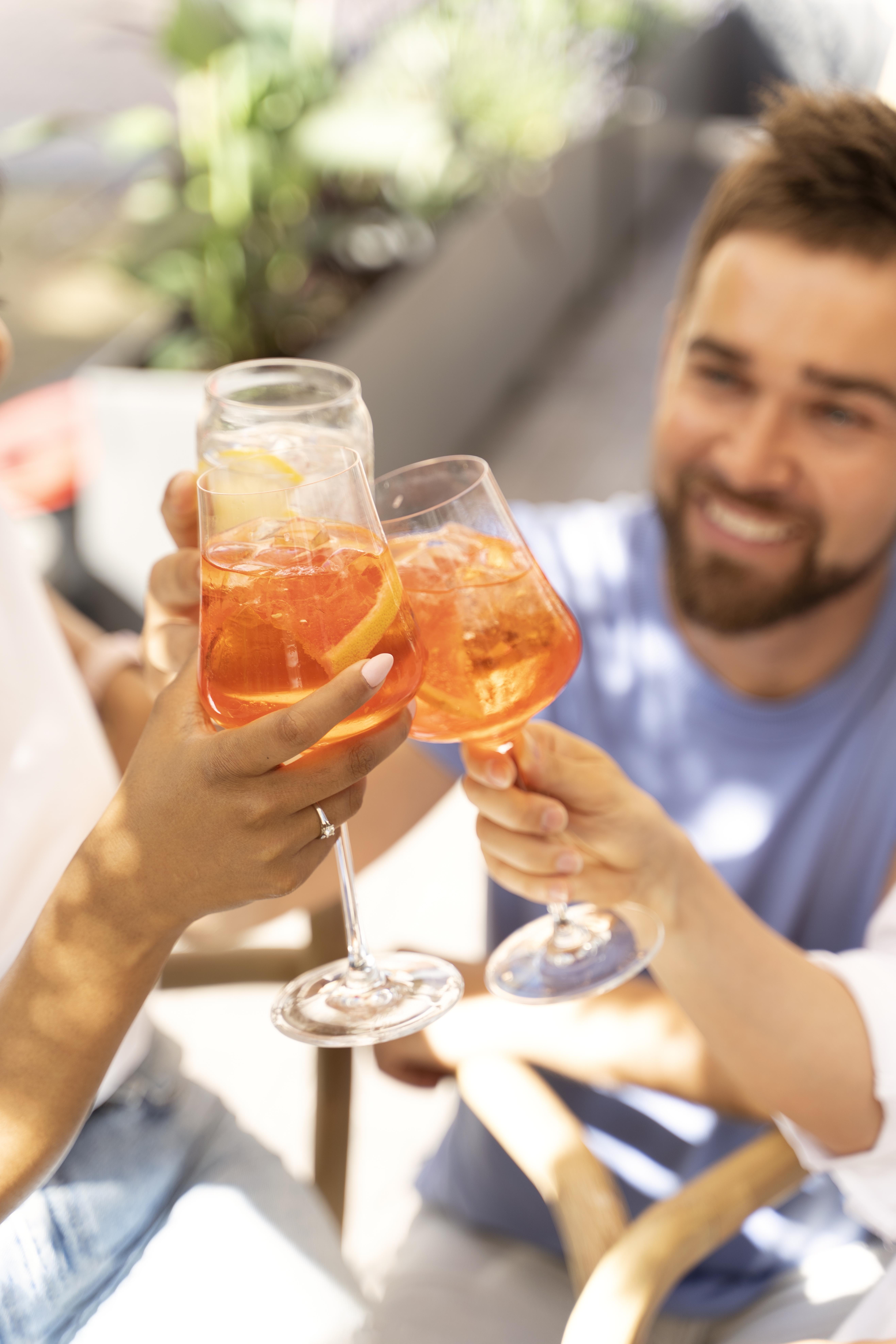 Grupo de amigos brindando con Aperol Spritz en Little Italy Gastro Fest Torremolinos — la Dolce Vita mediterránea en la Plaza de Toros