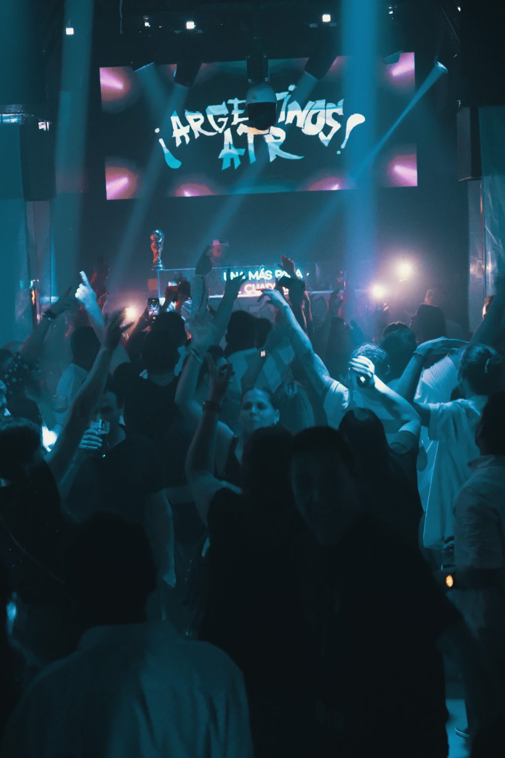 Público con los brazos en alto frente a la pantalla de ¡Argentinos ATR! y la réplica de la Copa del Mundo sobre la cabina